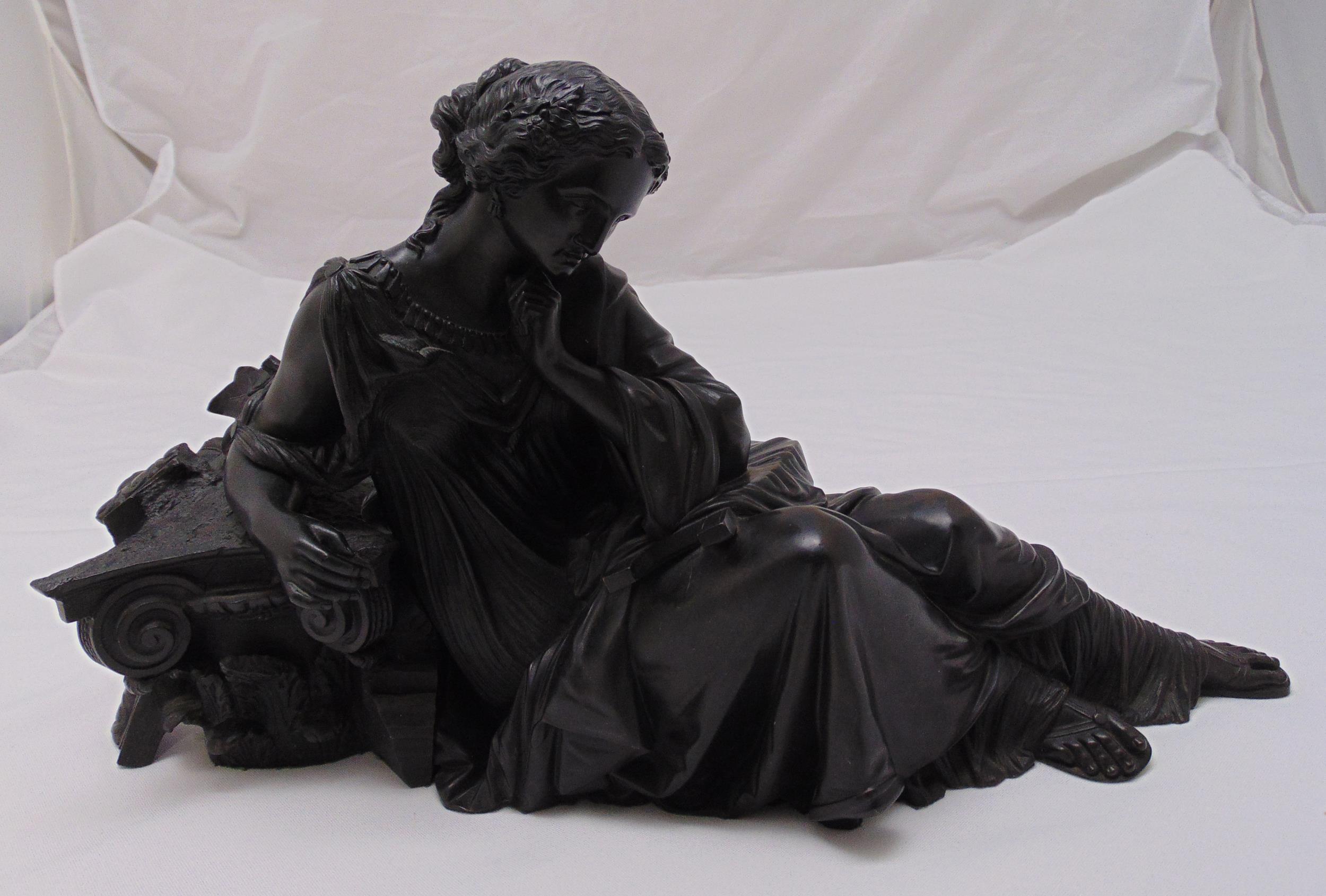 A cast bronze figurine of a recumbent classical lady, 24 x 45 x 12cm