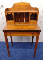 An Edwardian rectangular mahogany desk with fitted compartments, three drawers, hinged top with