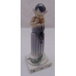 Royal Copenhagen figurine of a fawn playing a pipe perched on a column with applied lizard on raised