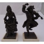 A pair of bronze figurines of a man playing a violin and a lady dancing both on raised white