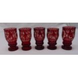 A set of five Bohemian etched ruby glasses decorated with animals, trees and buildings