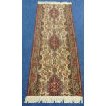 A wool runner, cream ground with repeating pattern and red border, 2.3m x 90cm