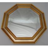 An octagonal wall mirror with moulded gilded wooden frame, 63.5 x 63.5cm