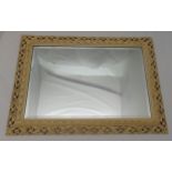 A rectangular carved and pierced painted wooden frame wall mirror, 63.5 x 89cm