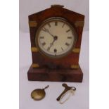 A walnut cased pendulum mantle clock of architectural form, the circular white dial with Roman