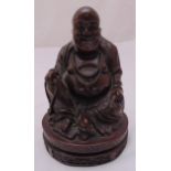 A carved hardwood seated Buddha on raised oval base, 24cm (h)