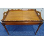A mahogany rectangular tea tray with pierced side handles on rectangular stand with tapering legs,
