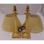 A pair of gilt metal columnular table lamp stands on raised square bases to include shades, 45cm (