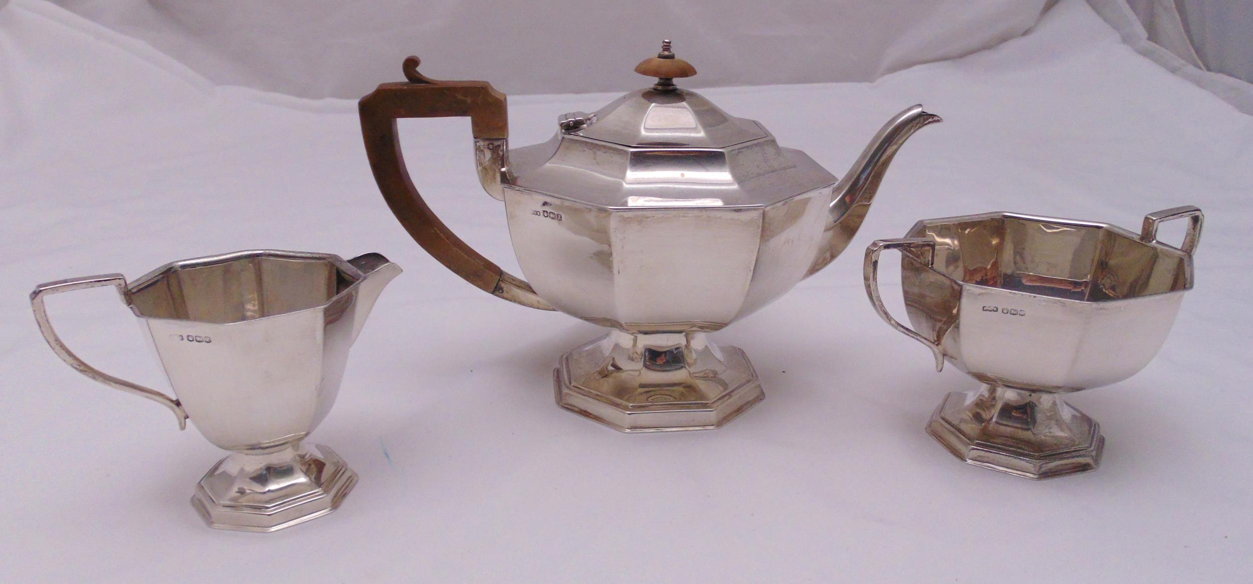 A hallmarked silver three piece teaset of panelled octagonal form to include a teapot, milk jug