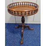 A circular mahogany occasional table with pierced gallery on three carved outswept legs with ball