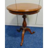 A circular mahogany side table on three outswept legs, 65 x 49cm