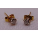 A pair of 9ct gold and diamond solitaire stud earrings