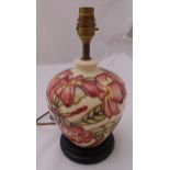 A Moorcroft table lamp of baluster form decorated with pink flowers on raised hardwood base, 29cm (