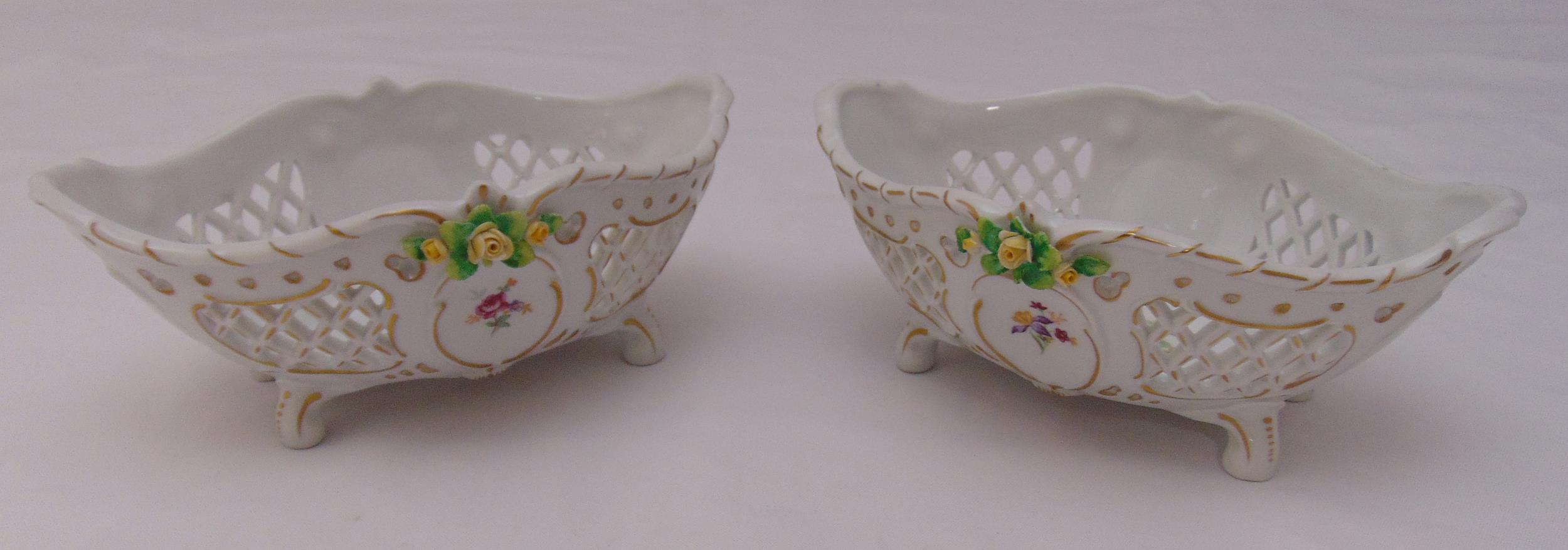 A pair of Sitzendorf porcelain oval pierced dishes on four scroll feet decorated with flowers and