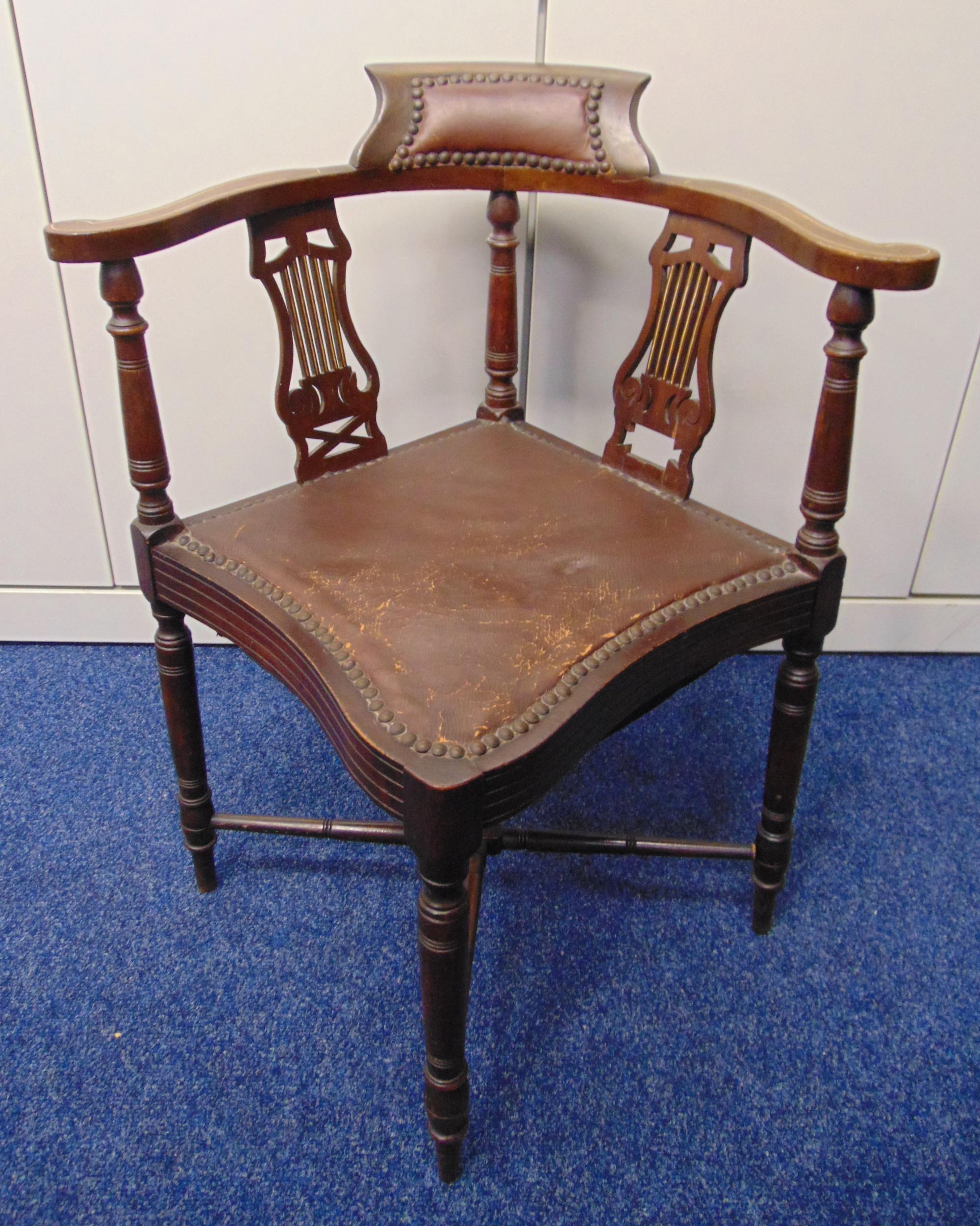 An Edwardian mahogany inlaid corner chair on four turned legs with leather upholstered seat and