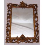A rectangular wall mirror with carved gilded scroll and leaf border, 61 x 52cm