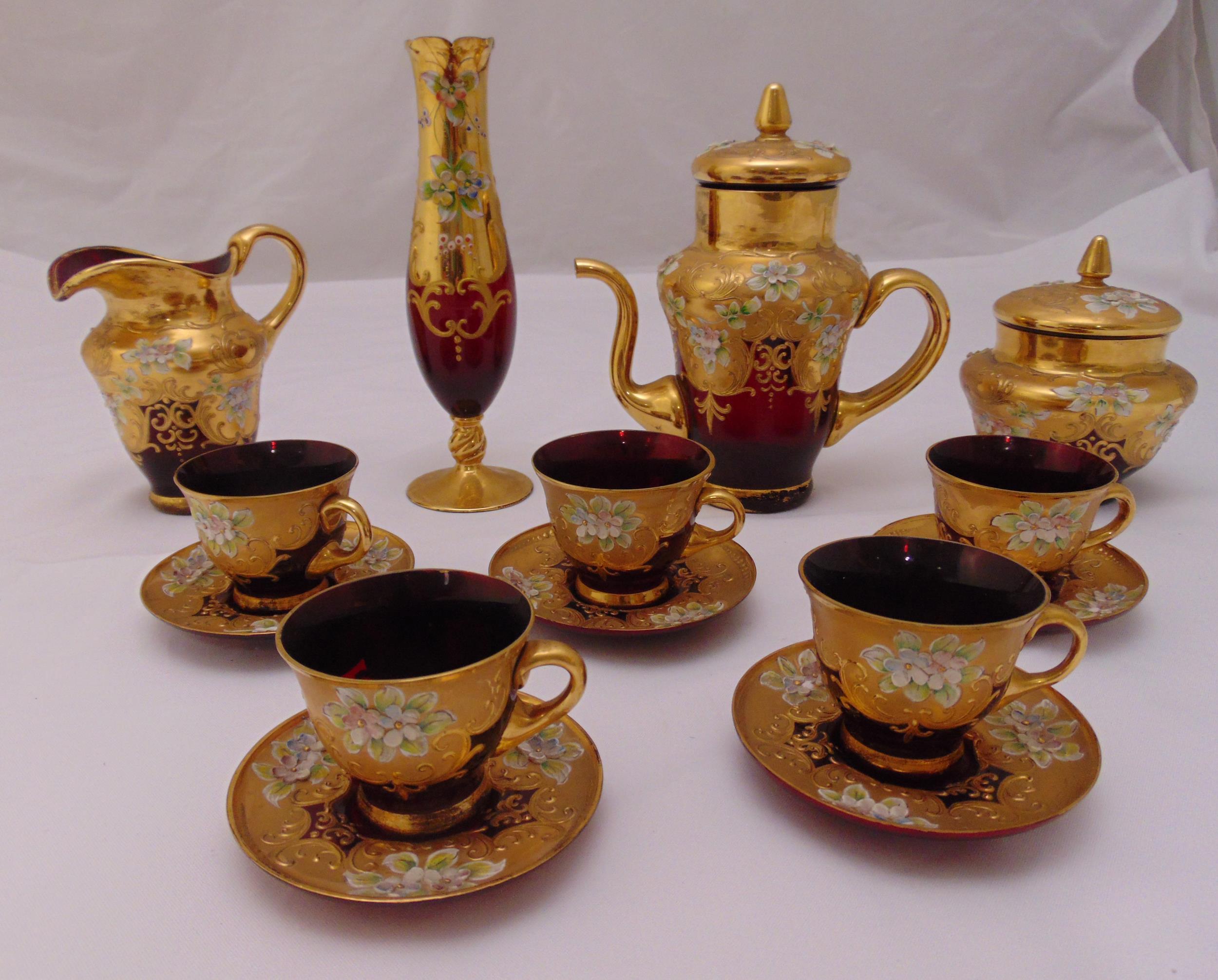 A Murano ruby red glass coffee set with over painted gilt decoration and applied porcelain flowers