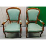 A pair of mahogany upholstered armchairs on scroll legs