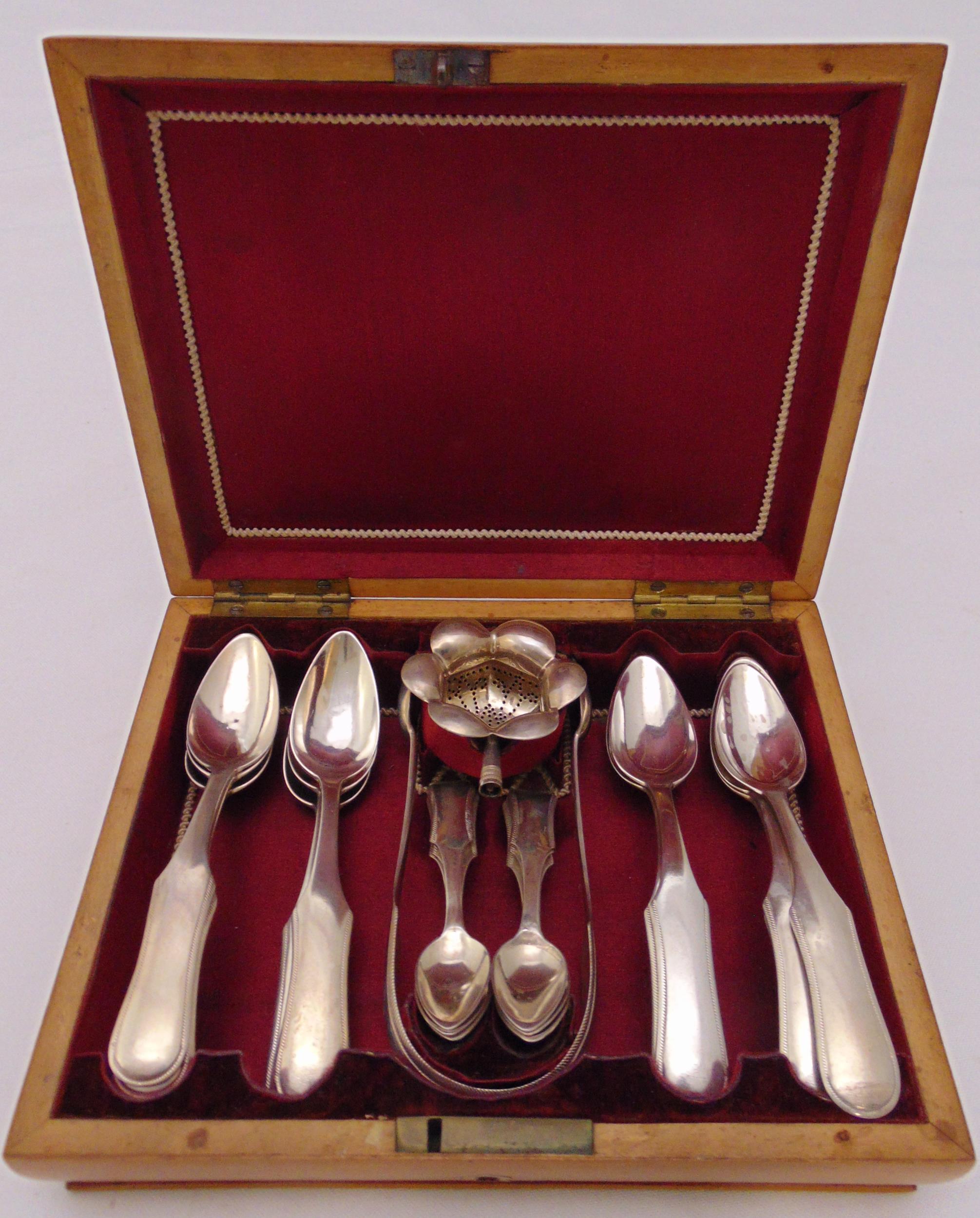 Eleven Dutch silver teaspoons, six matching coffee spoons, a pair of sugar tongs and a sifter