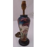 A Moorcroft baluster vase converted to a table lamp decorated with flowers on raised hardwood