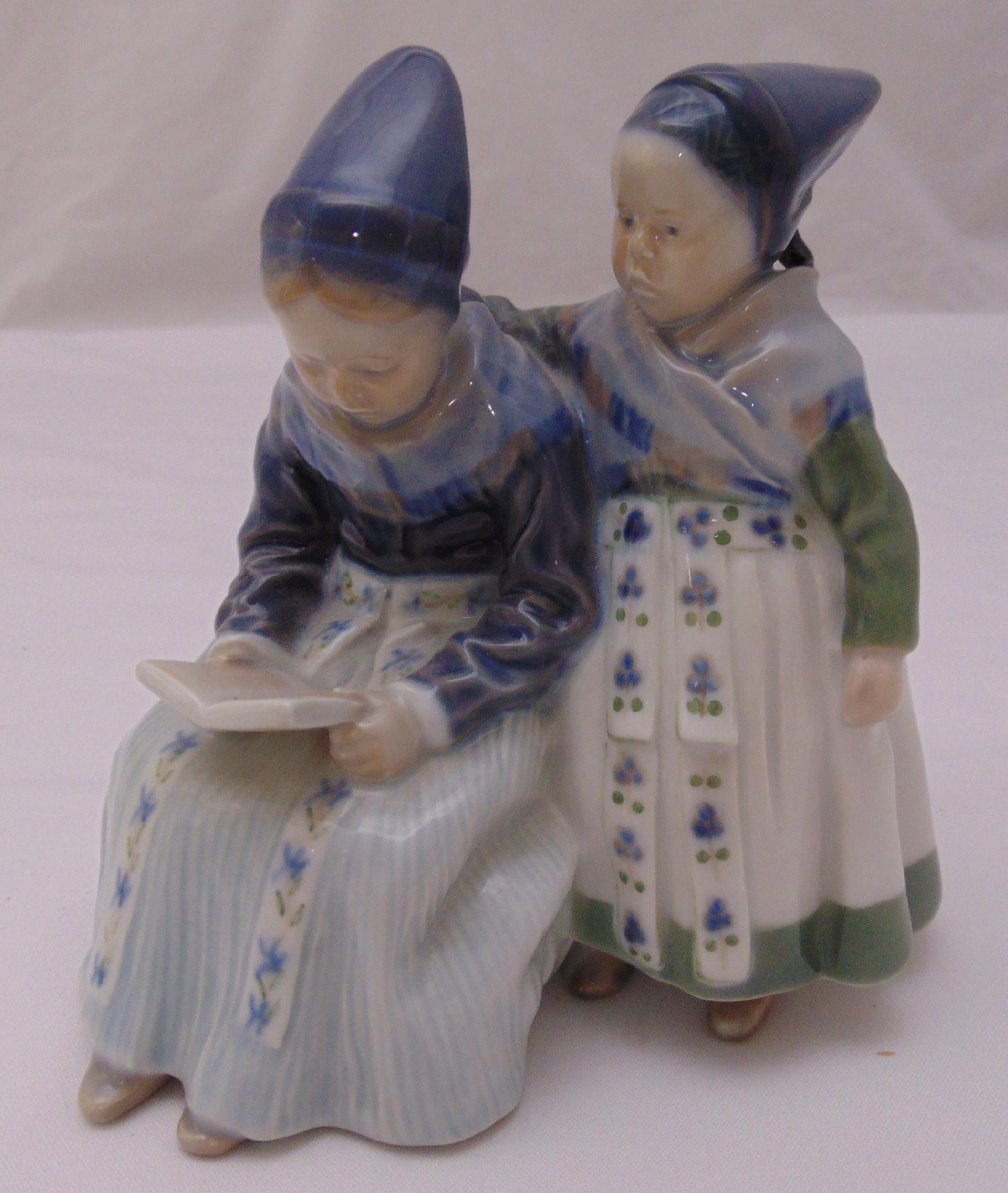 Royal Copenhagen figural group of two Amager girls, one reading 1395, marks to the base, 18cm (h)