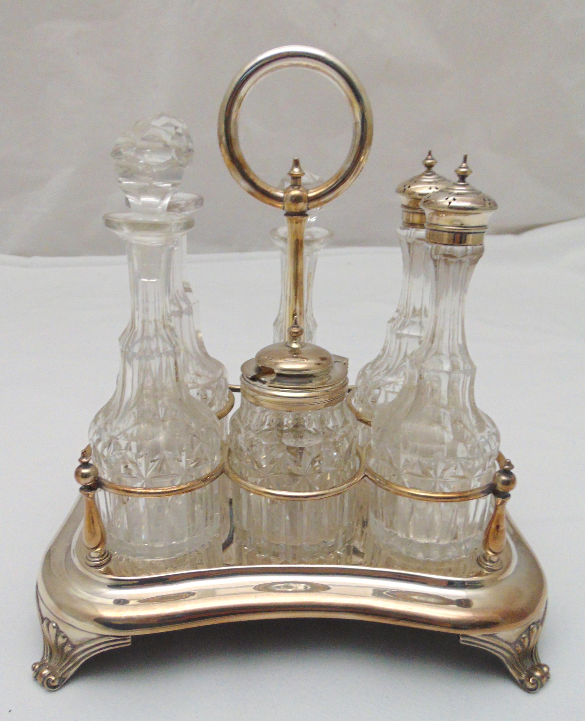 A silver plated condiment set to include six cut glass bottles with silver plated mounts