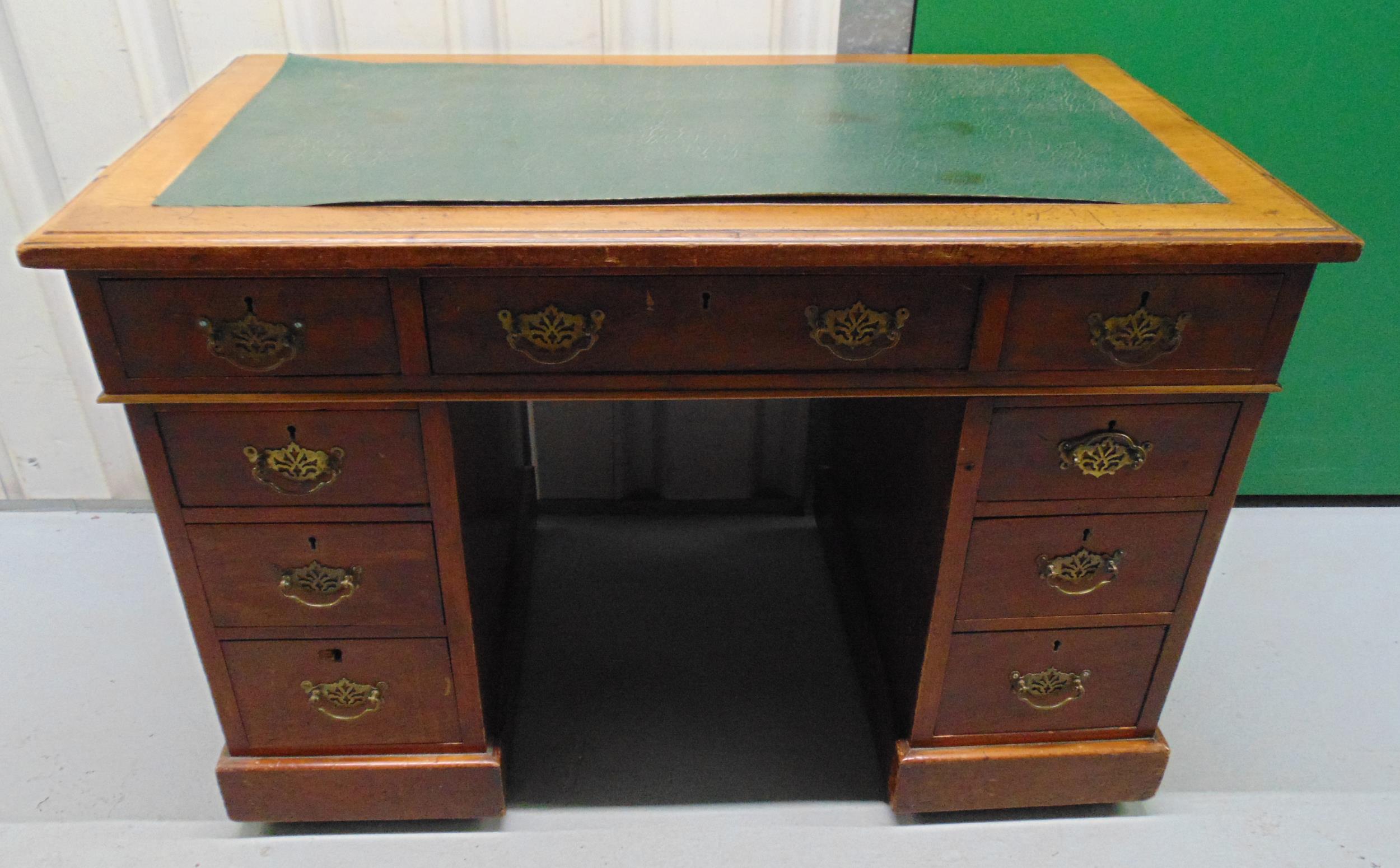 An early 20th century rectangular mahogany pedestal desk with tooled leather top and brass swing