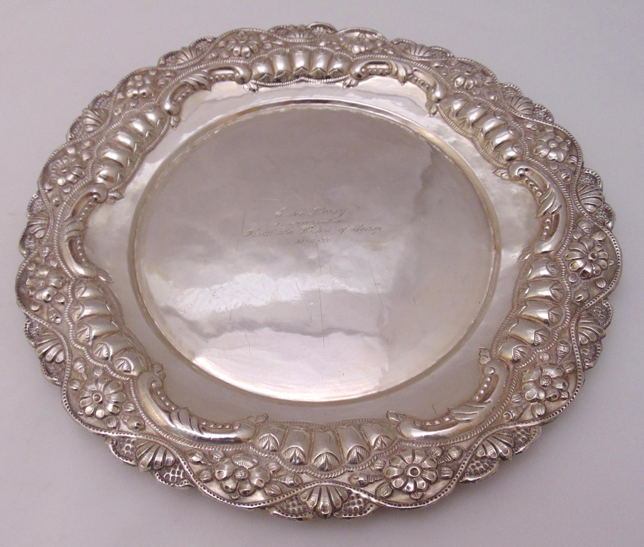 A white metal circular presentation salver with florally chased and pierced border, approx total