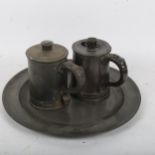 A George III pewter dinner plate, and a pair of pewter lidded mugs (3)