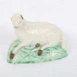 A late 18th century Ralph Wood type polychrome pottery figure of a recumbent ewe, length 16cm