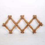 A Vintage pine simulated bamboo concertina hanging coat/hat rack, length 72cm