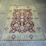 A red and green ground Persian design carpet, 358cm x 276cm (viewing by appointment only)
