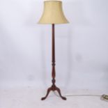 A mahogany fluted standard lamp and shade, on a carved tripod base, height to bayonet fitting 160cm