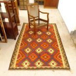 A large Kilim rug, 197cm x 134cm, and a 1920s oak armchair with cane-panelled back (seat needs re-