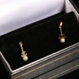 A pair of unmarked gold pearl drop earrings