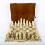 A set of green and white onyx chessmen, with matching onyx chess board, 36cm x 36cm, King height 9cm