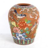 A terracotta vase with enamelled floral decoration, height 28cm