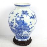 A Chinese blue and white porcelain vase with painted detailed floral design, attached wood base,