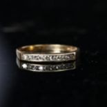 A 9ct gold ring set with a band of 9 small diamonds
