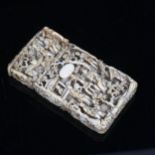 A Chinese ivory card case, relief carved and pierced village scene, 8.5cm x 4.5cm