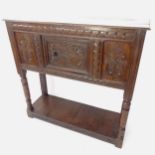 An Antique oak cabinet on stand, with allover relief carved panelled decoration, single cupboard