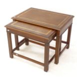 A reproduction mahogany nest of 2 occasional tables, with leather tops, widest 65cm