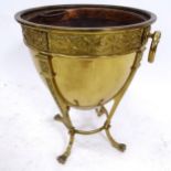 An embossed brass Adam style coal bucket, on claw feet, with ring handles, W36cm, H46cm