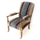 An early 20th century upholstered armchair on bobbin turned legs