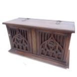 An Antique oak coffer, with Gothic carved and pierced design panelled front, on bun feet, W94cm,