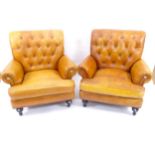 A pair of modern brown leather upholstered armchairs