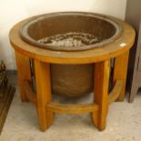 A brass planter in a circular oak stand, diameter 78cm, H57cm