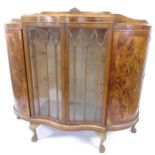 A 1930s walnut 4-door display cabinet of serpentine form, W150cm, H135cm, D46cm