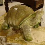 A weathered concrete statue of a tortoise