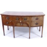 A George III mahogany crossbanded bow-front sideboard, with 5 fitted drawers with being a cellarette